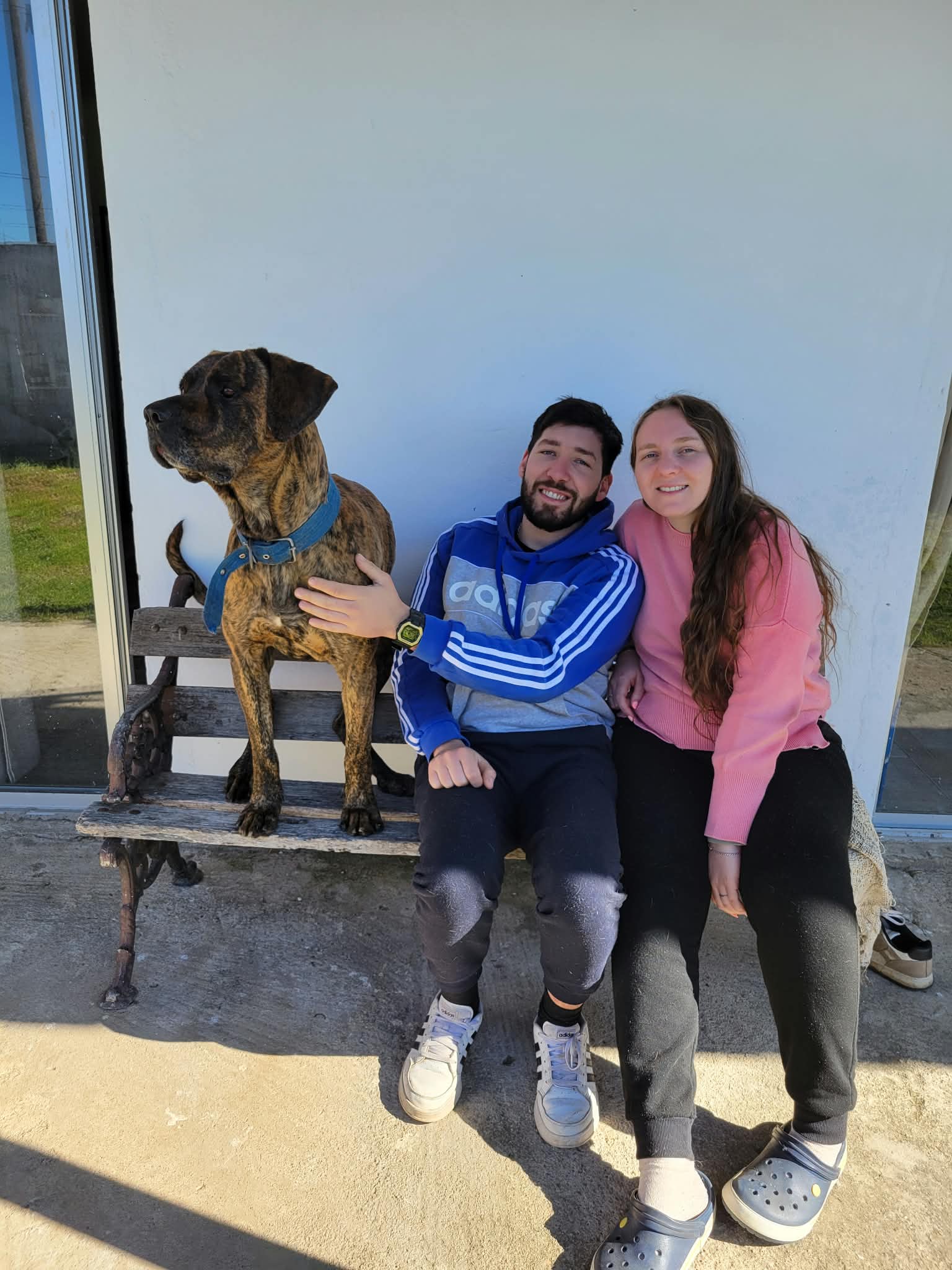 Karen y su pareja sentados junto a su perro