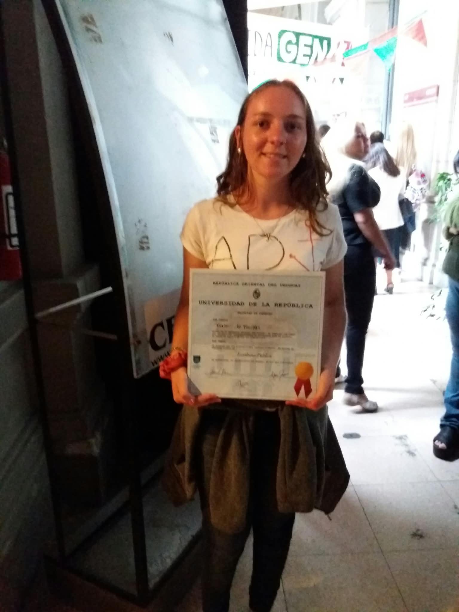 Karen sosteniendo su título de la Universidad de la República